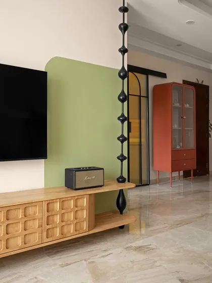 Another view of the TV unit, showing the playful contrast between the organic green shape and the geometric black divider. This detail adds a bold, modern spirit to the otherwise classic space.