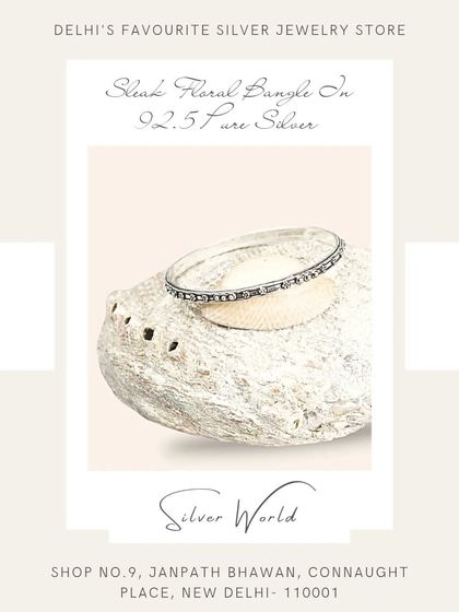 This sleek, stackable floral silver bangle is perfect for creating a layered look. The continuous floral pattern adds a touch of delicate detail.