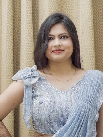 A closer portrait in the same silver saree, focusing on the model's expression and the blouse detailing.