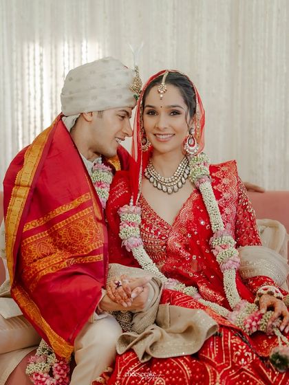 The couple holding hands, sharing a look of love and happiness during their wedding rituals.