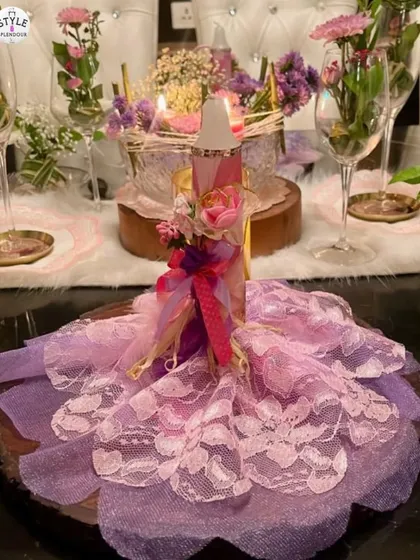 These 'Dancing Candles' are dressed in lacy net fabric to create a bouncy gown effect. Decorated with floral embellishments, they serve as a whimsical and romantic centerpiece.