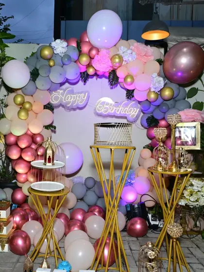 A full view of the elegant tropical-themed photo booth at Lono Tropical, featuring a balloon arch, neon sign, and chic props.