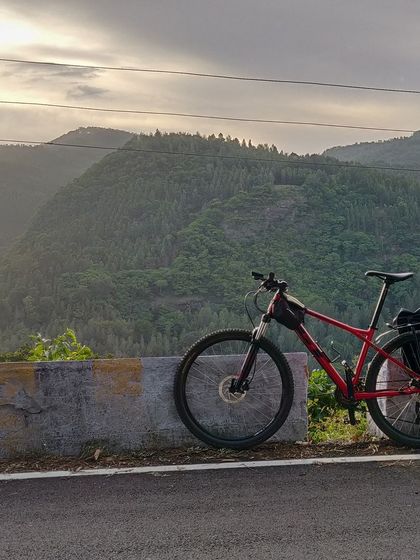 A bike rests against a barrier, overlooking the dense forests of Yercaud. This shot captures the feeling of being on top of the world, surrounded by nature.