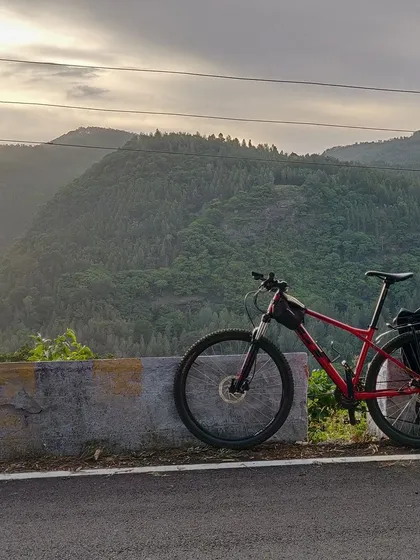 A bike rests against a barrier, overlooking the dense forests of Yercaud. This shot captures the feeling of being on top of the world, surrounded by nature.