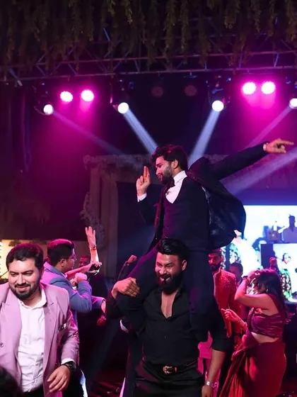 The groom enjoying the Sangeet night to the fullest, carried on the shoulders of his friends. It's all about creating high-energy, fun-filled memories.