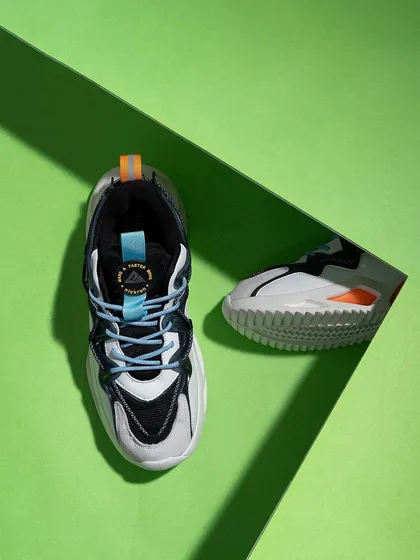 A top-down shot of sneakers on a bright green background with a strong shadow line. The graphic composition and complementary colors make this a bold and eye-catching image.