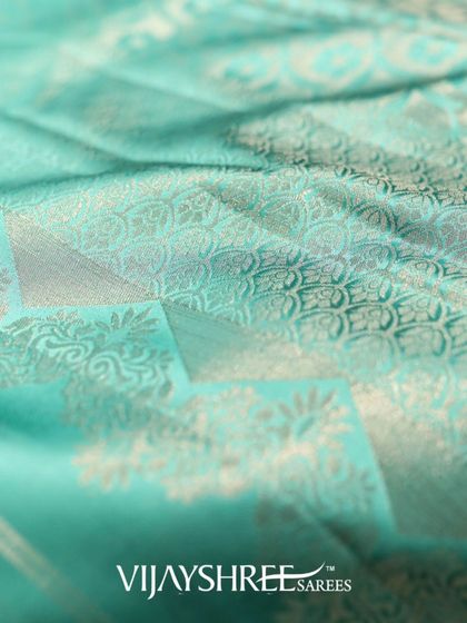 The texture and sheen of the floral Kanjivaram, highlighting the interplay of silk and silver zari.
