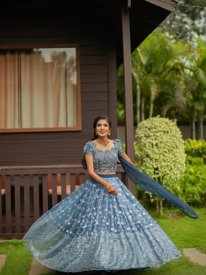 Swathi looking radiant for her outdoor engagement ceremony. The twirl shot shows off her beautiful blue lehenga, and the makeup was designed to be fresh and bright for the daytime event.