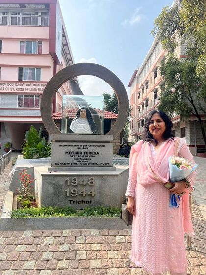 Standing by the Mother Teresa statue at Mount Carmel College. Her life of service is an eternal inspiration.