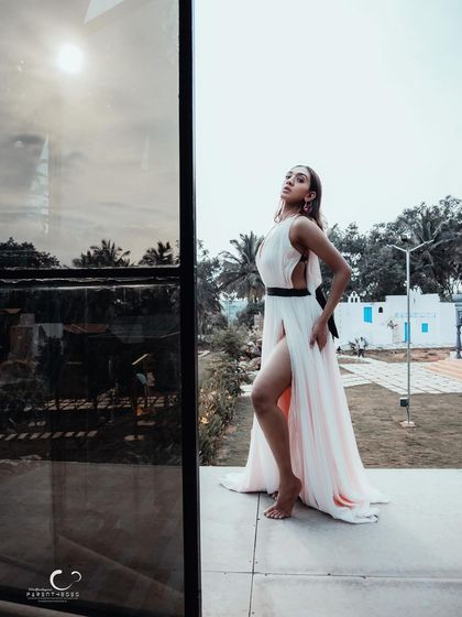 A stunning full-length shot that uses reflection and natural light to create a modern and artistic fashion portrait.