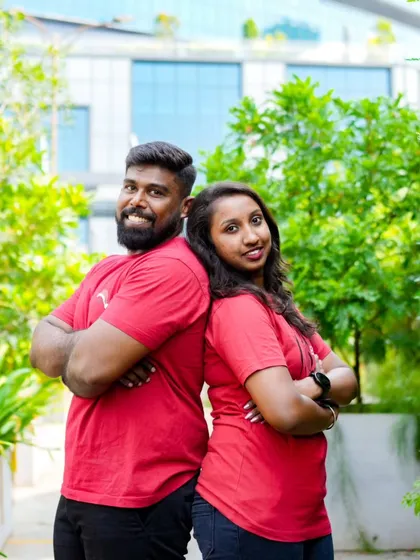 A fun back-to-back pose in a green, leafy setting. Their matching red shirts add a nice pop of color.