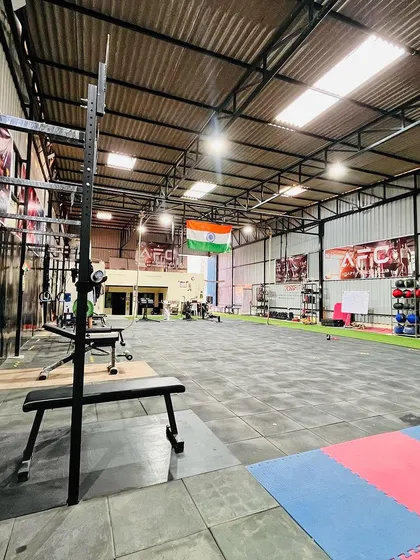 A wide view of our main training floor. This shot gives you a sense of the scale of our facility, with ample room for everything from grappling fundamentals to intense CrossFit WODs. You can see the squat racks, open mat space, and dedicated areas for different training styles.