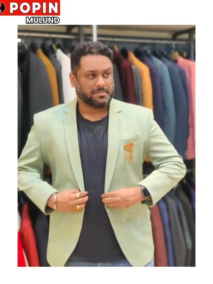 This client is trying on a light green blazer with a gold brooch. It's a fresh and stylish option for a daytime event or a summer party.