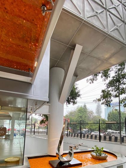 The entrance of MAP during a preview, with the water feature filled with marigolds, blending modern architecture with Indian tradition.