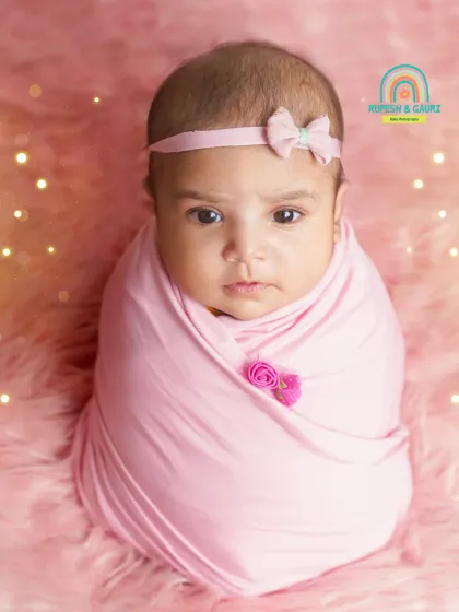 A classic portrait of a 2-month-old baby girl, wrapped snugly in pink. Even at this age, we can capture beautiful, calm moments.