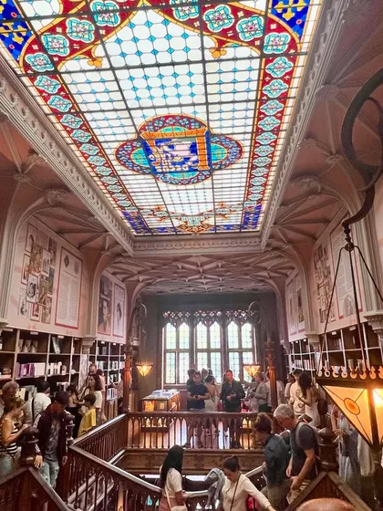 Standing under the vast stained-glass ceiling of Livraria Lello. The way light filters through the colored glass, illuminating the carved wood and bustling bookstore below, creates an unforgettable atmosphere. It’s a perfect fusion of art and architecture.