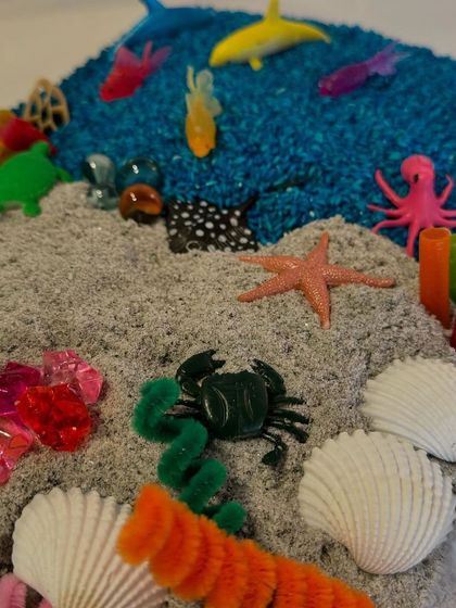 An ocean adventure in a box! This sensory kit combines colored rice, sand, shells, and sea creatures to create a mini underwater world for your child to explore.