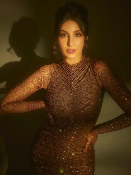 For her appearance on Jhalak Dikhhla Jaa, I put Nora Fatehi in this shimmering, form-fitting gown by Itrh. The ruched fabric and built-in gloves create a sophisticated and high-fashion television look.