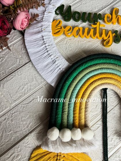 A detailed close-up of the rainbow and pom-pom clouds on the custom business sign. Every knot and tassel is made with care to represent your brand beautifully.