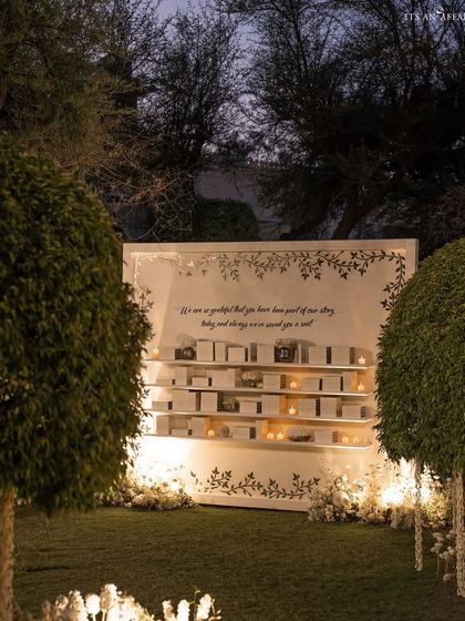 The beautifully designed seating chart display, framed by greenery and soft lighting, guiding guests to their seats.