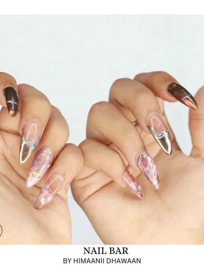 A mismatched set featuring pink marble and bronze chrome nails. We love mixing and matching different trends.