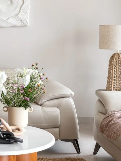 Details from the living room, where fresh flowers, a jute lamp, and textured throws add softness and life to the neutral palette.