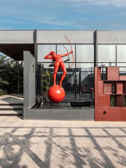 The exterior of the SNN Estates office features a bold red sculpture of an archer, creating a memorable landmark and a strong brand statement.