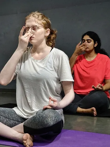 We go beyond just physical postures by focusing on pranayama, or breathwork. Here, my students are practicing Nadi Shodhana (alternate nostril breathing), a powerful technique to calm the mind and reduce anxiety.