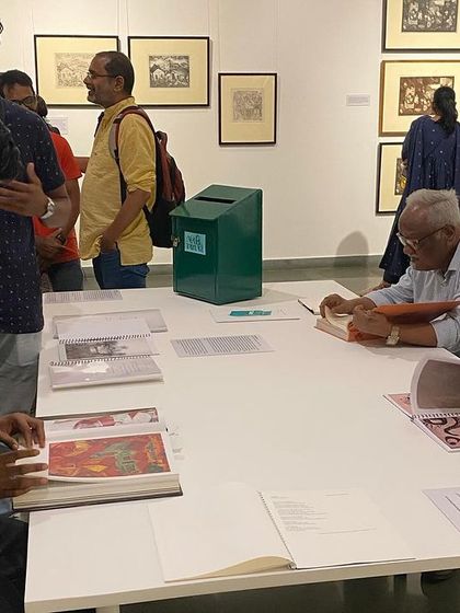Visitors at the library table, looking through the books and journals.