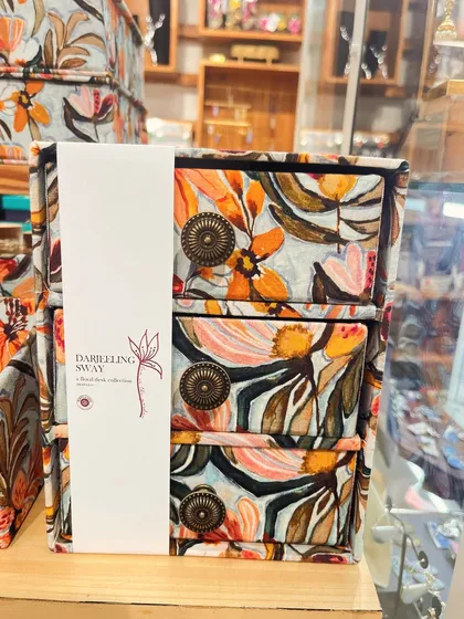 A close-up of the 'Darjeeling Sway' three-drawer organizer. The antique-style knobs add a touch of vintage charm to the vibrant floral cotton fabric.
