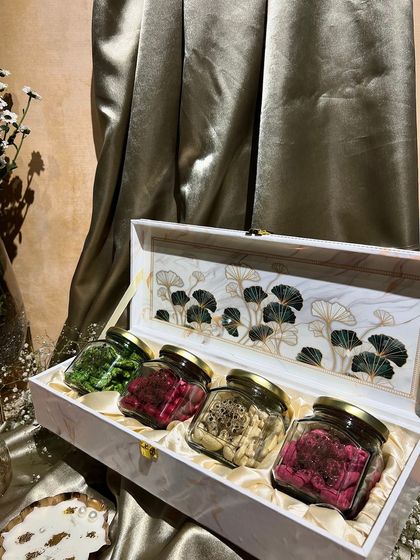 This elegant white box with a nature-inspired design holds four jars of colorful, flavored dry fruits. A healthy and beautiful gift for the festive season.