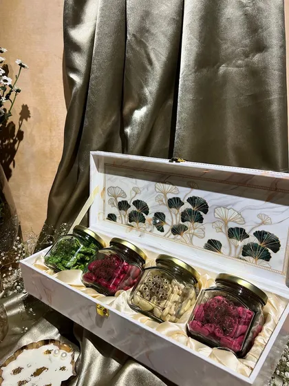 This elegant white box with a nature-inspired design holds four jars of colorful, flavored dry fruits. A healthy and beautiful gift for the festive season.