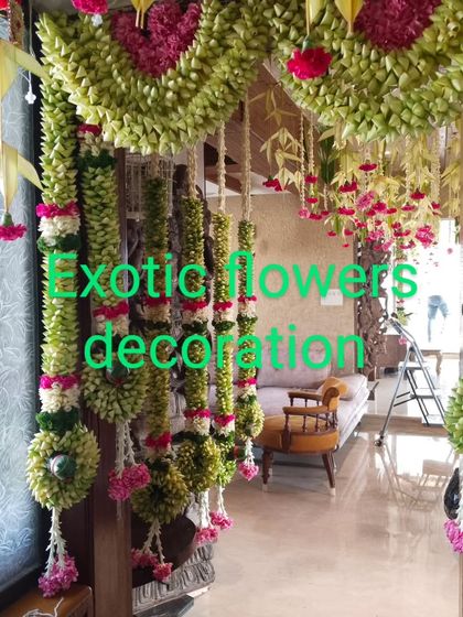 A traditional and artistic entrance decoration. We use folded palm leaves to create intricate patterns, complemented by hanging garlands of fresh flowers for a unique, handcrafted look.