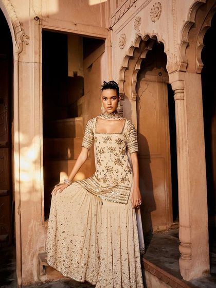 A full view of the beige sequined sharara-lehenga, showcasing its graceful flare and sophisticated sparkle.