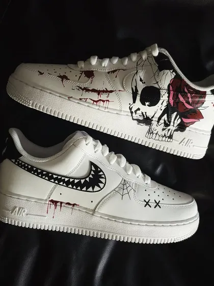 The full pair of Halloween custom sneakers, featuring a skull, spiderwebs, and a monster-mouth swoosh.