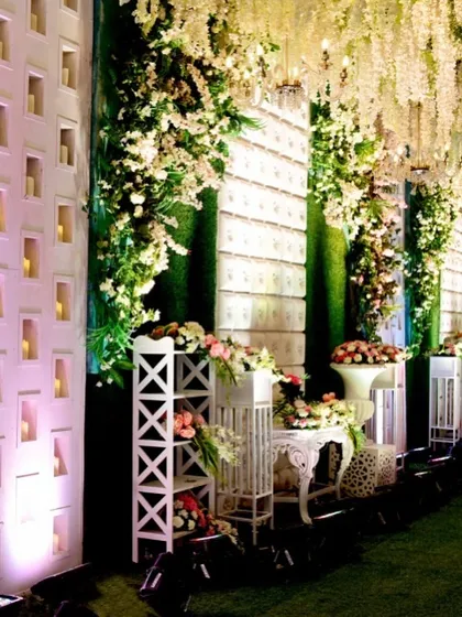 A beautiful detail of the entrance decor, featuring candle-lit niches within a textured white wall. This adds a soft, romantic glow and architectural interest to the space.