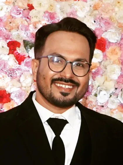 A portrait against a floral backdrop. The groom's makeup is balanced to look good in photos, ensuring he looks his best in every memory captured.
