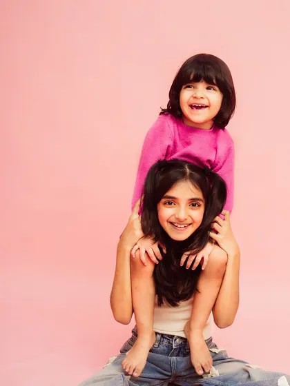 Piggyback rides and big smiles. The bond between these sisters is so clear in this fun and energetic portrait.