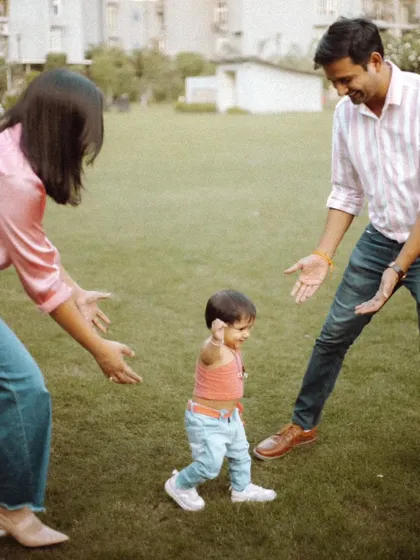 A candid shot of a toddler taking confident steps towards their smiling parents. Our patient approach allows us to capture these fleeting, once-in-a-lifetime family moments.