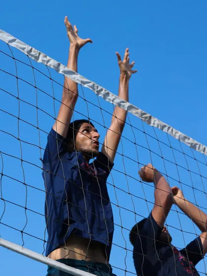 The peak of a practice block, with arms fully extended over the net. This is the moment where good positioning and a powerful jump come together.