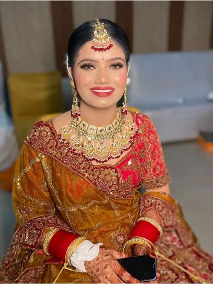 A smiling bride showcasing her complete look, with a neat bridal bun that keeps the focus on her beautiful makeup and jewelry. This is a popular and timeless choice for the wedding day.