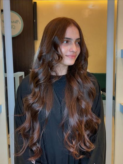 A stunning copper brown global color. This rich, warm shade looks incredibly healthy and vibrant, styled in long, flowing waves.