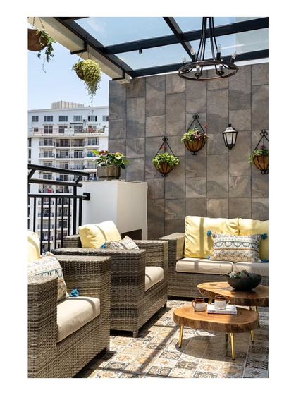 Another view of the balcony lounge, highlighting the sandalwood slab tables and Spanish planters that infuse the area with greenery and connect to the Mediterranean theme.