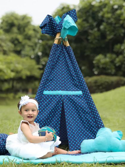 A happy camper in her teepee. This outdoor session combines the beauty of nature with a fun, personal touch for a unique portrait.