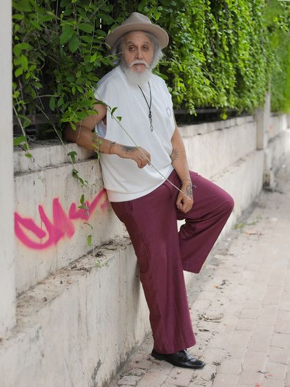 A relaxed, leaning pose against a weathered wall with a pop of graffiti, adding an edgy, urban element to the portrait.