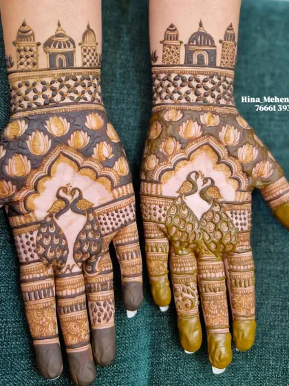 A classic traditional Indian mehendi featuring symmetrical peacocks, a lotus pond, and palace architecture. The contrast between the fresh green henna and the dark stain shows the design's beautiful progression.