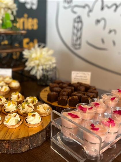 A dessert spread at a corporate event, featuring mini fruit tarts, chocolate brownies, and a rose-flavored mousse. This offers a variety of sweet bites to conclude a meal.