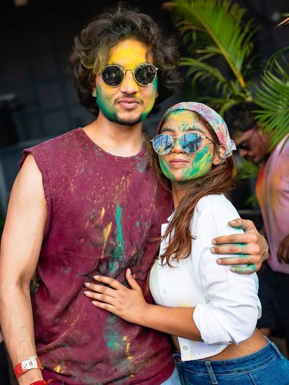A couple poses for a picture amidst the Holi festivities. I create a fun and inclusive atmosphere perfect for celebrating with friends and loved ones.
