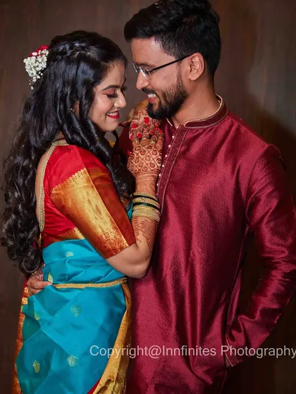 A classic romantic portrait of a couple in traditional Indian wear. The rich colors of their outfits and the tender interaction make for a beautiful memory.