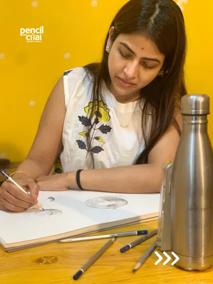 With pencils scattered around her, this student is focused on her still life drawing, a testament to the quiet dedication in our studio.